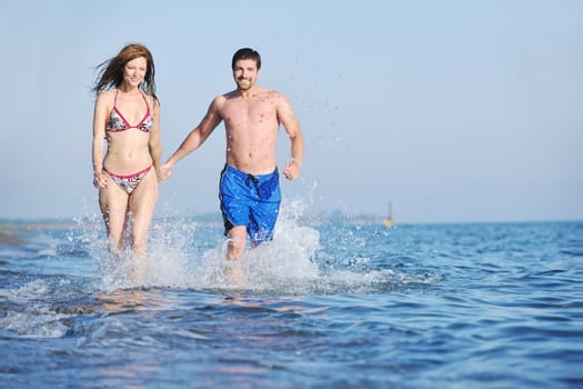 happy young couple have romantic time on beach at sunset