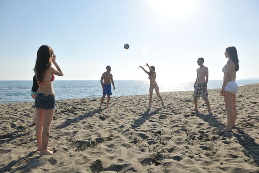 young people group have fun and play beach volleyball at sunny summer day