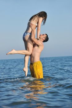 happy young couple have romantic time on beach at sunset