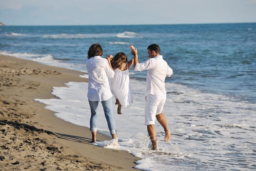 happy young family in white clothing have fun at vacations on beautiful beach 