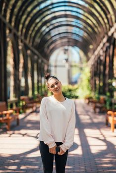 Woman walks along a picturesque alley in summer park.