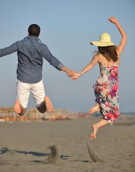 couple on beach with travel bag representing freedom and funy honeymoon concept