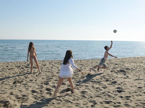 young people group have fun and play beach volleyball at sunny summer day