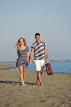 couple on beach with travel bag representing freedom and funy honeymoon concept