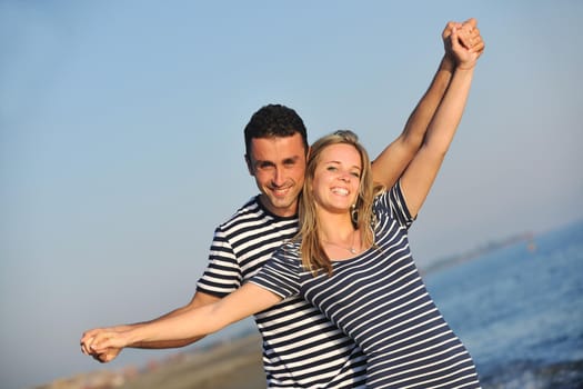 happy young couple have romantic time on beach at sunset