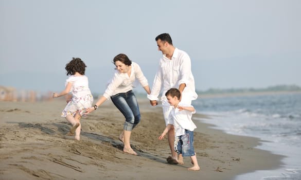 happy young family have fun and live healthy lifestyle on beach