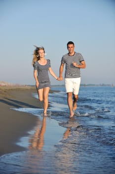 happy young couple have romantic time on beach at sunset