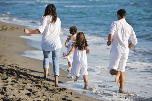 happy young family in white clothing have fun at vacations on beautiful beach 