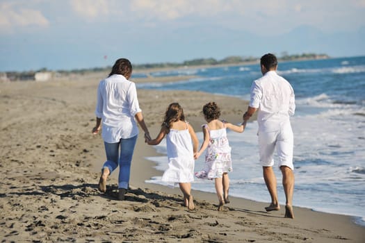 happy young family in white clothing have fun at vacations on beautiful beach 