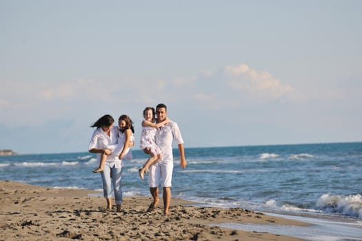 happy young family in white clothing have fun at vacations on beautiful beach 