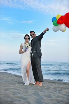 happy just married young couple celebrating and have fun at beautiful beach sunset