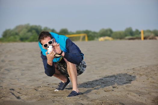 young creative amateur photographer taking snapshot photo with sunglasses on sunset