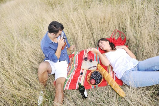 happy young couple enjoying  picnic on the countryside in the field  and have good time