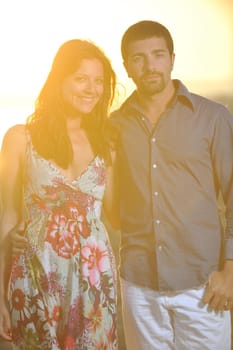 happy young couple have romantic time on beach at sunset