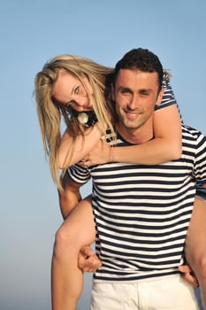 happy young couple have romantic time on beach at sunset