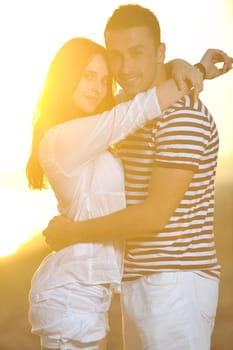 happy young couple have romantic time on beach at sunset