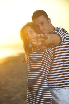 happy young couple have romantic time on beach at sunset