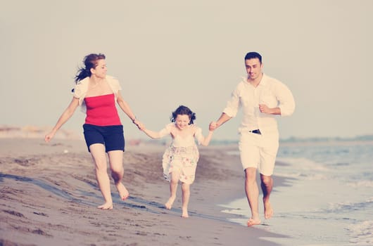 happy young family have fun and live healthy lifestyle on beach