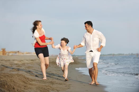 happy young family have fun and live healthy lifestyle on beach