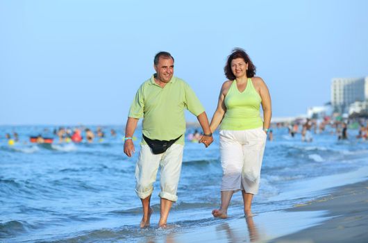 happy senior mature elderly people couple have romantic time on beach at sunset 