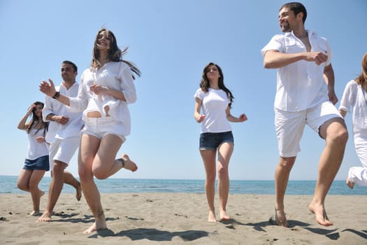 happy people group have fun  run and jump  on beach beautiful sand  beach