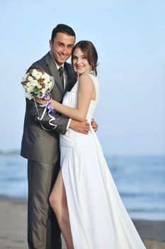 happy just married young couple celebrating and have fun at beautiful beach sunset