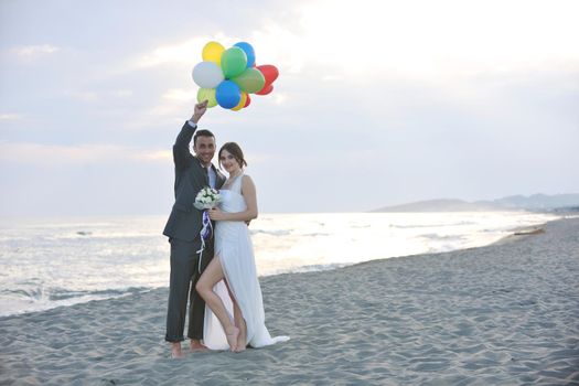 happy just married young couple celebrating and have fun at beautiful beach sunset