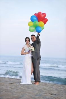 happy just married young couple celebrating and have fun at beautiful beach sunset