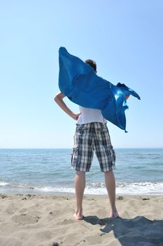 funny superhero standin at beach on hot sand