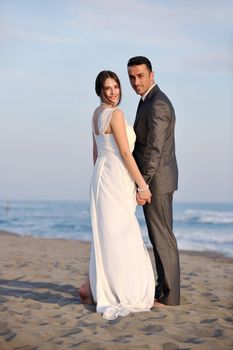 happy just married young couple celebrating and have fun at beautiful beach sunset