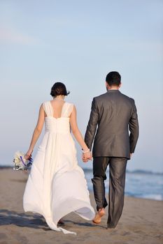 happy just married young couple celebrating and have fun at beautiful beach sunset