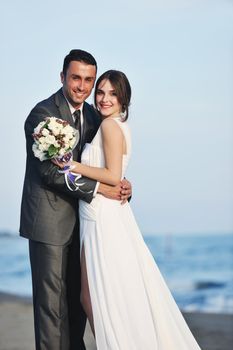 happy just married young couple celebrating and have fun at beautiful beach sunset