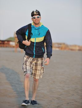 young man relaxing on beach at sunset