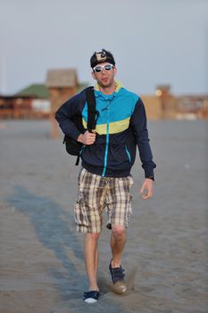 young man relaxing on beach at sunset