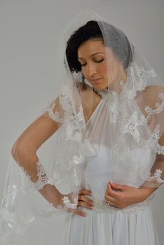 Portrait of a beautiful woman dressed as a bride isolated on white background in studio