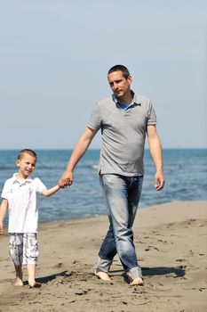 happy young  father and son have fun and enjoy time on beach at sunset and representing healthy family and support concept