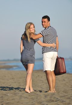 couple on beach with travel bag representing freedom and funy honeymoon concept