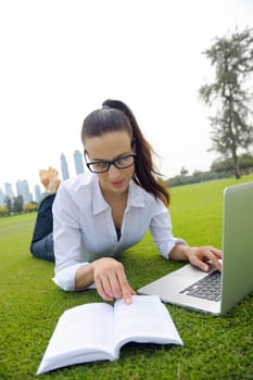 happy young student woman with laptop in city park study