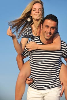 happy young couple have romantic time on beach at sunset