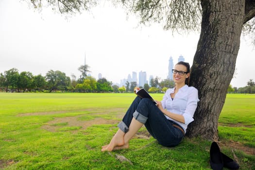 Young student woman reading a book and study in the park