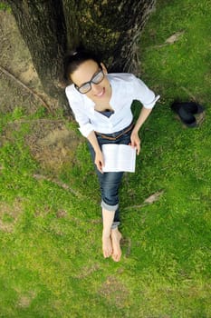 Young student woman reading a book and study in the park