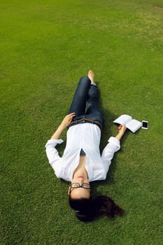 Young student woman reading a book and study in the park