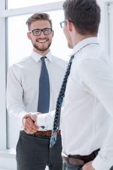 close up.handshake of business partners standing outside an office window. concept of partnership