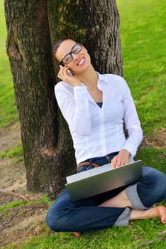 happy young student woman with laptop in city park study