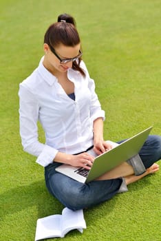 happy young student woman with laptop in city park study