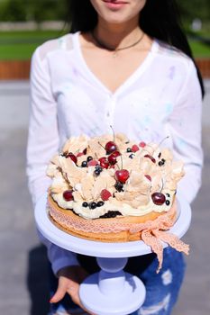 Woman wearing white blouse keeping birthday cake. Concept of sweets and tasty food for party.