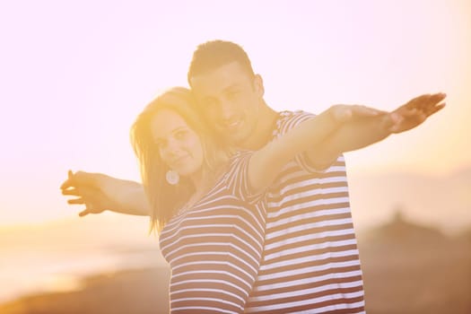 happy young couple have romantic time on beach at sunset