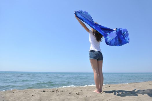 beautiful young woman on beach with scarf relax smile and have fun