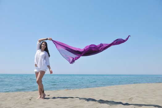 beautiful young woman on beach with scarf relax smile and have fun