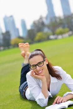 Young student woman reading a book and study in the park